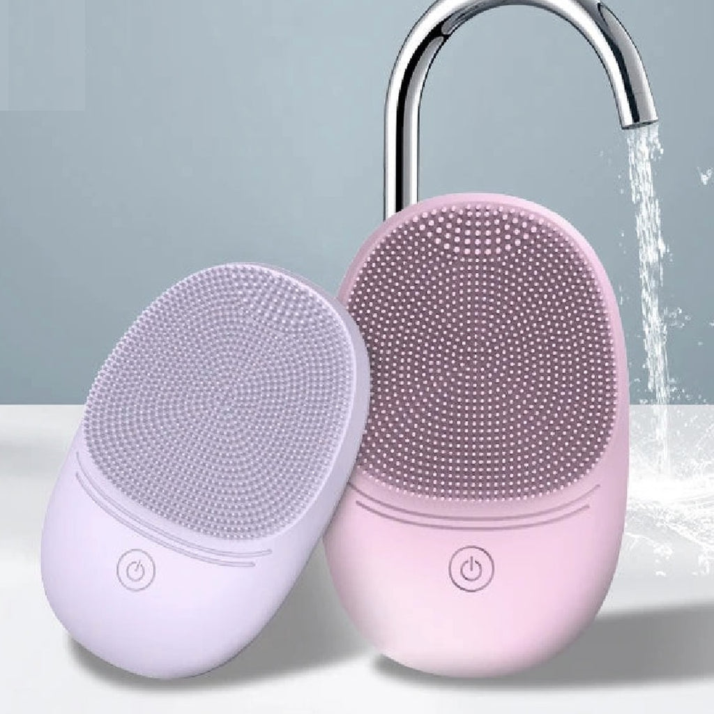 Pura Sonic Cleansing Brush in lavender and pink under running water