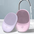Pura Sonic Cleansing Brush in lavender and pink under running water