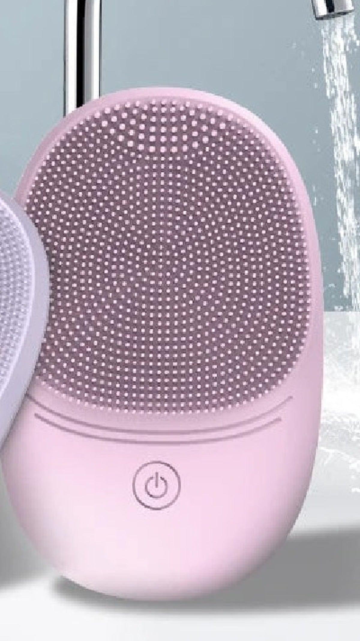 Pink Pura Sonic Cleansing Brush close-up with water stream on silicone bristles